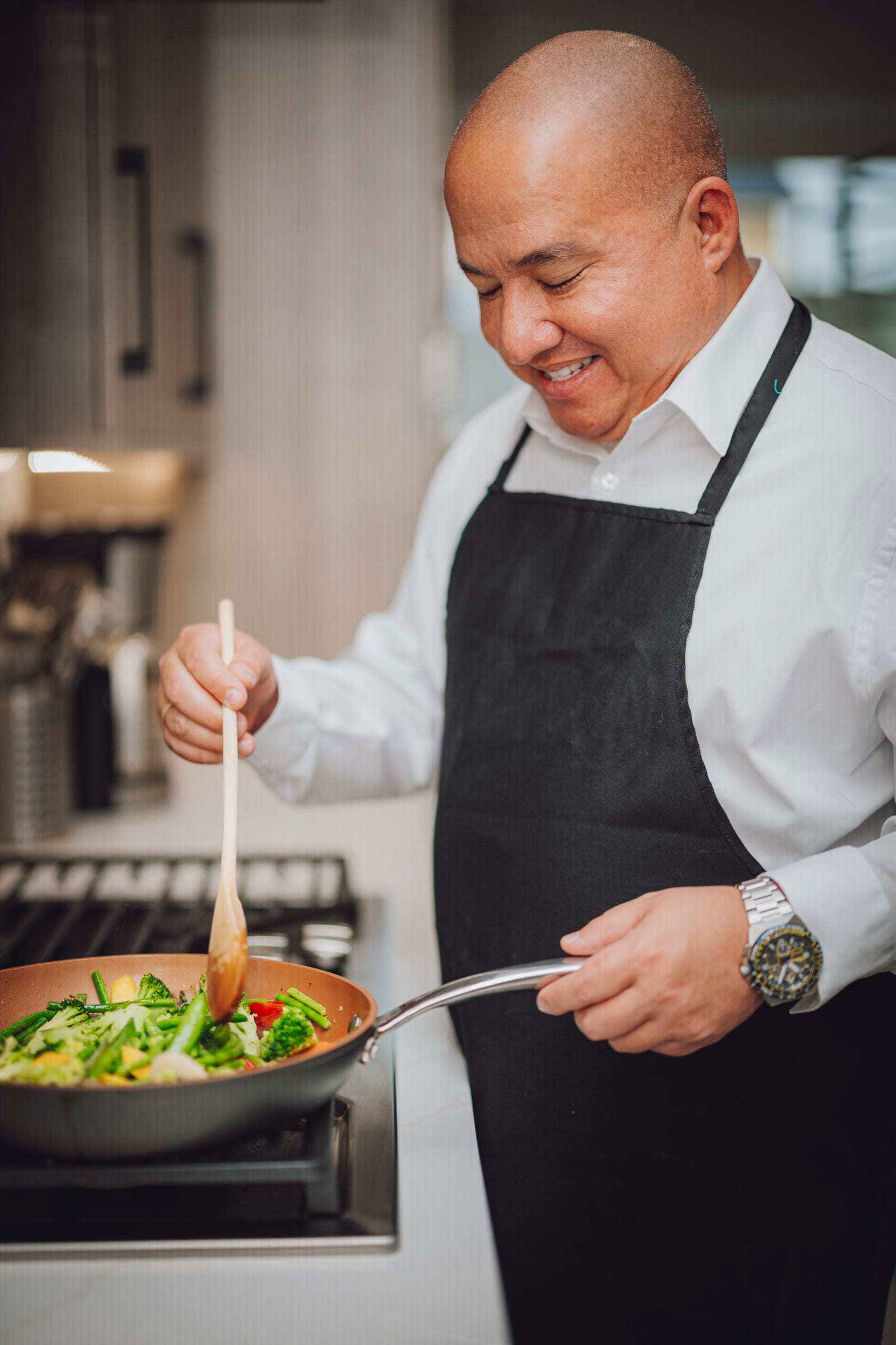 Chef stirring vegetables on a stovetop during a Richland business branding session.